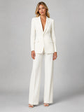 Woman wearing a white tailored blazer and wide-leg trouser set, front view