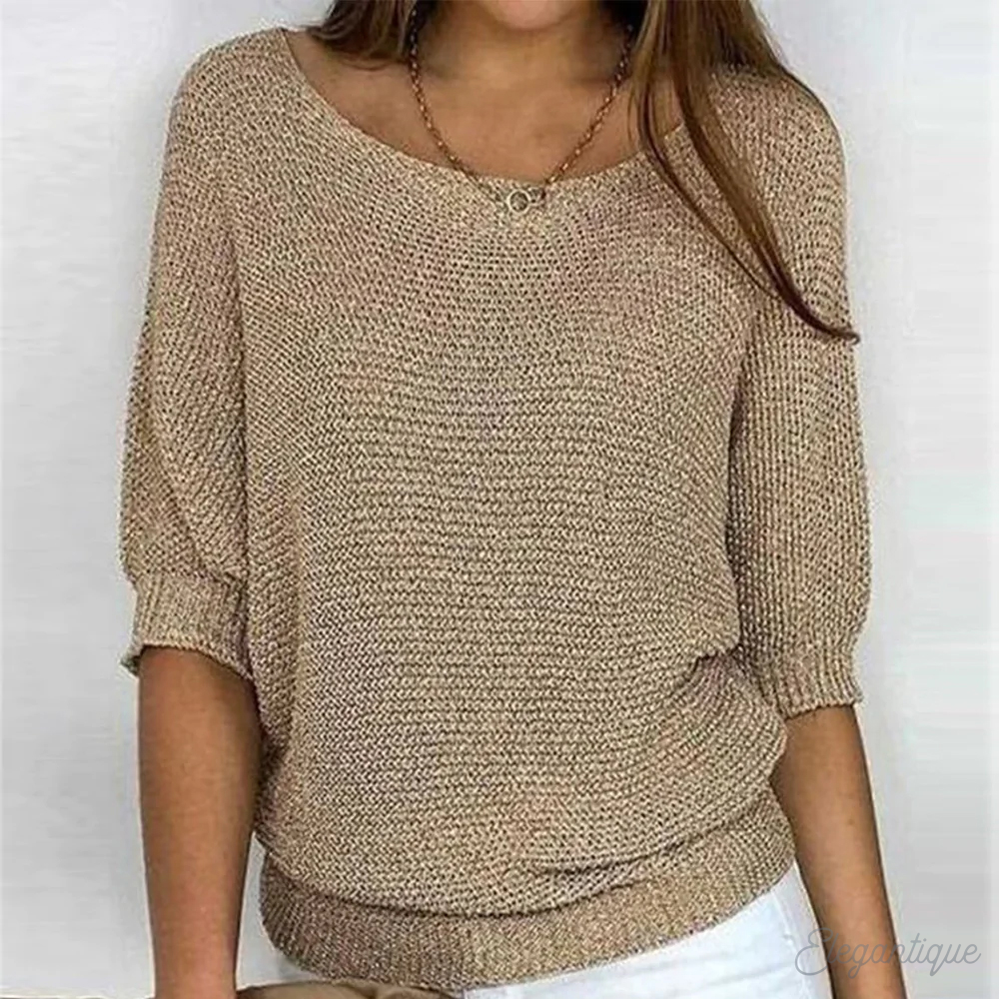 Woman wearing a relaxed round-neck knit sweater with wide sleeves, front view