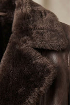 Full-length view of brown faux leather shearling-collar jacket on model